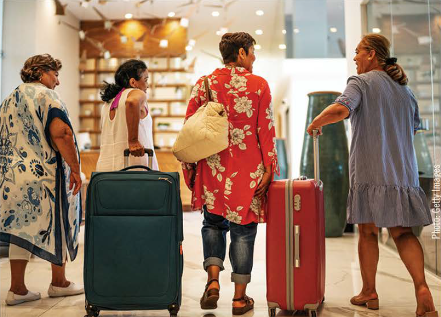 Four women walking with travel bags