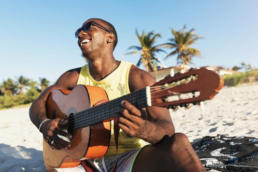 Caribbean man playing guitar on the beach
